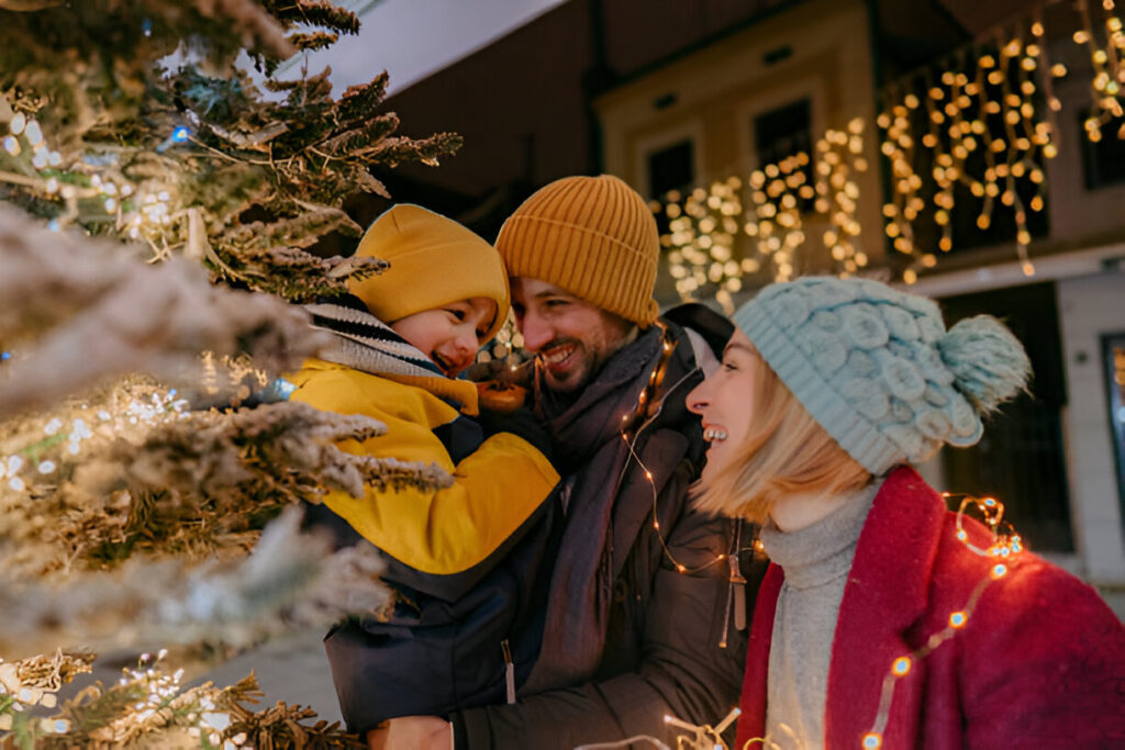 A family walking through a Portland neighborhood admiring beautifully decorated Christmas lights.